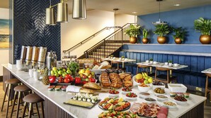 Um buffet de café da manhã com diversas opções de comida, uma escada e áreas de estar.