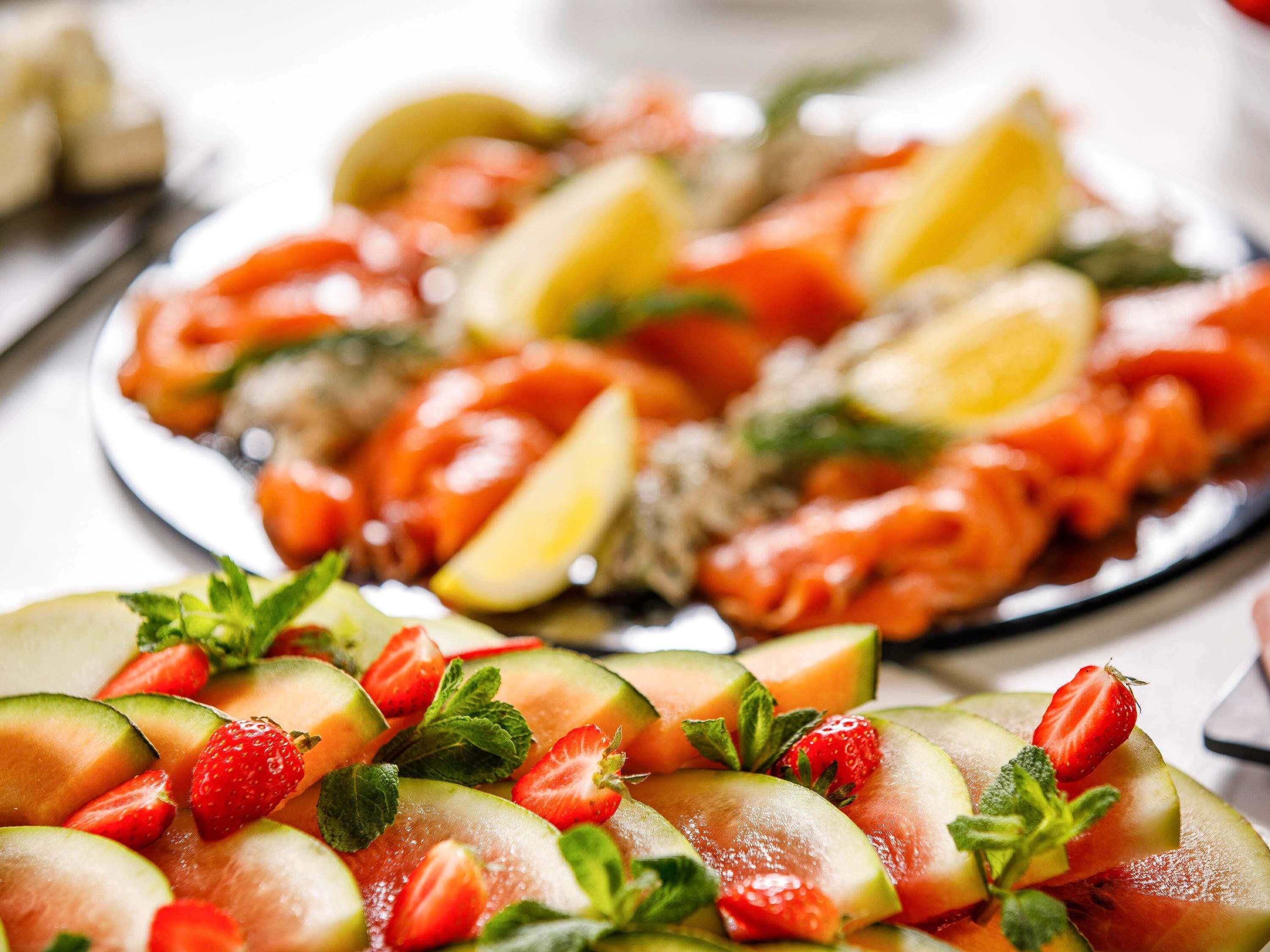 A plate of sliced fruits and vegetables, including strawberries and cucumbers.