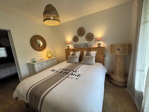 A bedroom with a bed, bedside lamps, a wall-mounted mirror, and a floor lamp. - House in Arcachon, 900 meters from the beach. (Andernos-les-Bains)