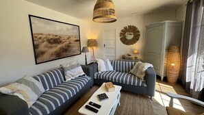 A modern living room with a sectional sofa, a coffee table, and a large framed picture on the wall. - Arcachon house 900m from the beach. (Andernos-les-Bains)