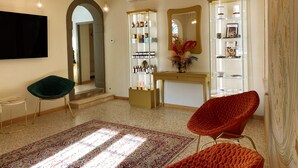 Un interior moderno con un espejo grande, tocador y una silla roja.