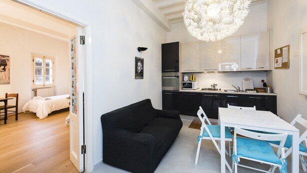 A modern kitchen with black cabinets, a white countertop, and a hanging light fixture. - Pitti Three - Two Bedroom Apartment, Sleeps 4 (Firenze)