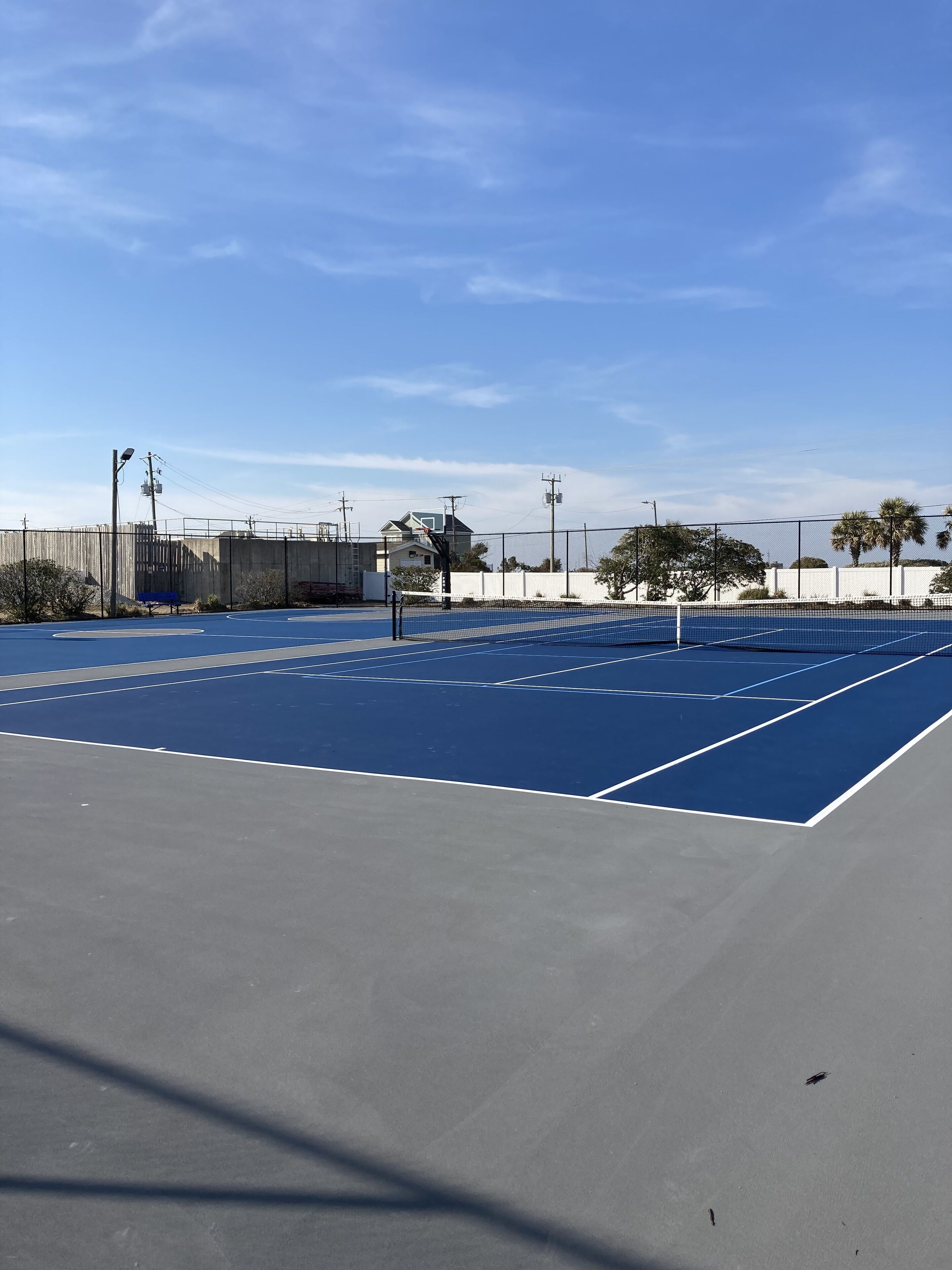 Een tennisbaan met een blauwe ondergrond en witte lijnen.