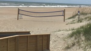 Une plage avec une promenade en bois menant à l’entrée de la plage.