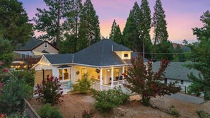 Une maison dotée d’un porche, d’un patio couvert et d’un jardin bien entretenu.