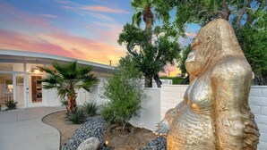 Un bâtiment moderne avec une grande statue dorée dans la cour.