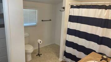 Regadera, secadora de cabello, toallas, papel de baño