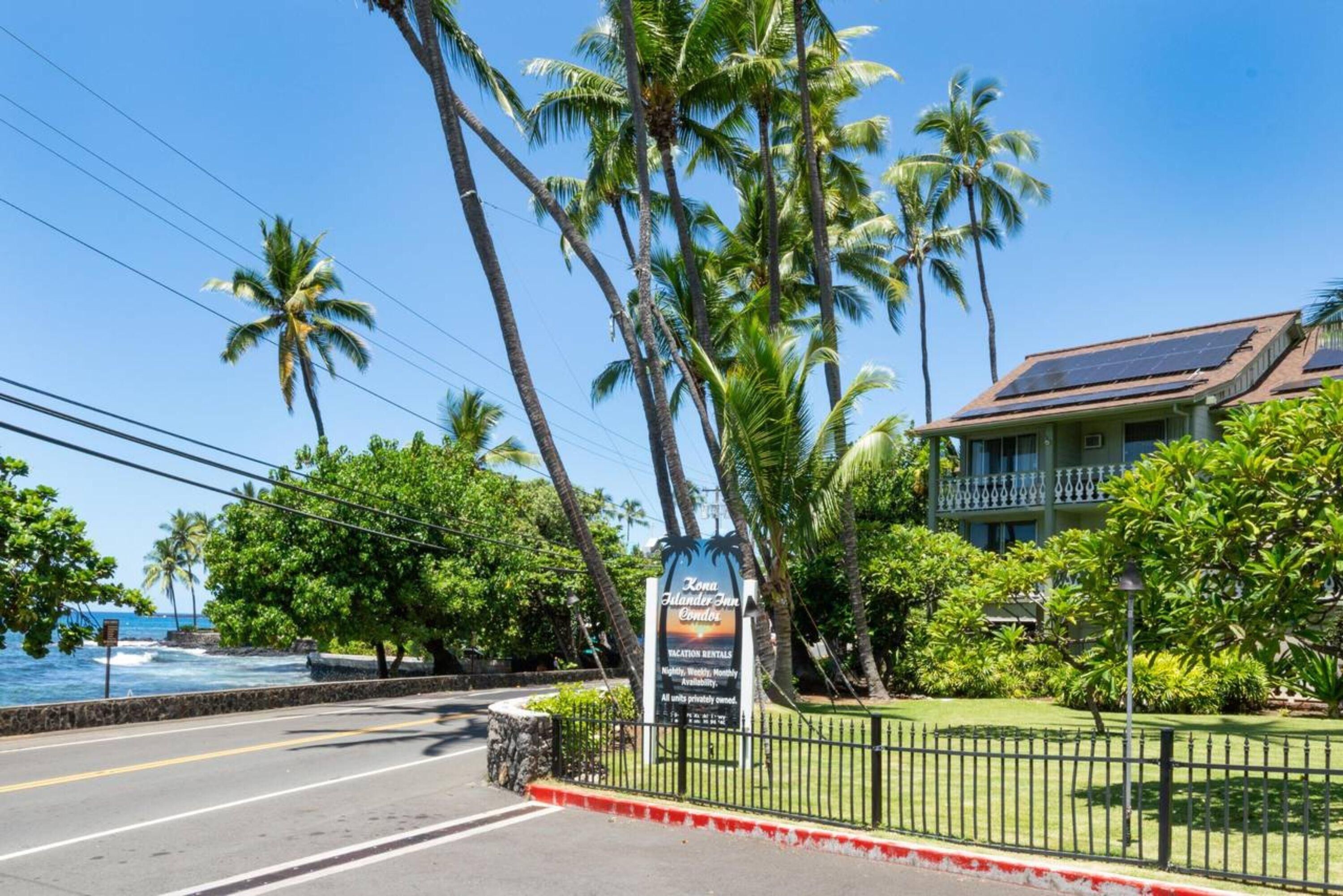 A beachfront property with a sign for 'Zone Islander Inn & Condo' offering vacation rentals.