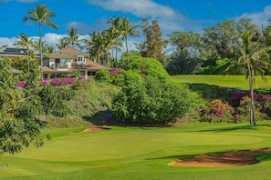 A golf course with a house in the background.