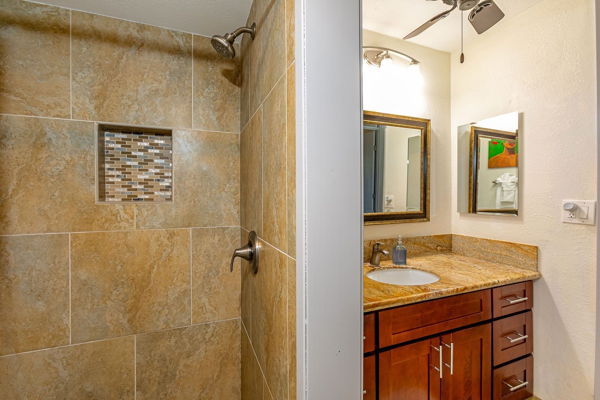 A bathroom with a shower, a sink, and a mirror.