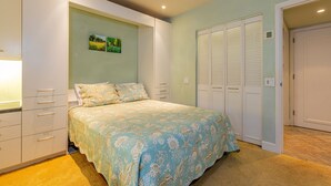 Ein Schlafzimmer mit einem Bett, einem Kleiderschrank und einem Schrank.