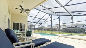 A covered outdoor area with lounge chairs and a pool. - Park Villa 4 Bedroom Villa by RedAwning (Davenport)