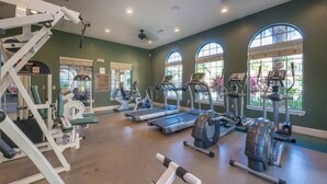 A gym with treadmills, elliptical machines, and weightlifting equipment.