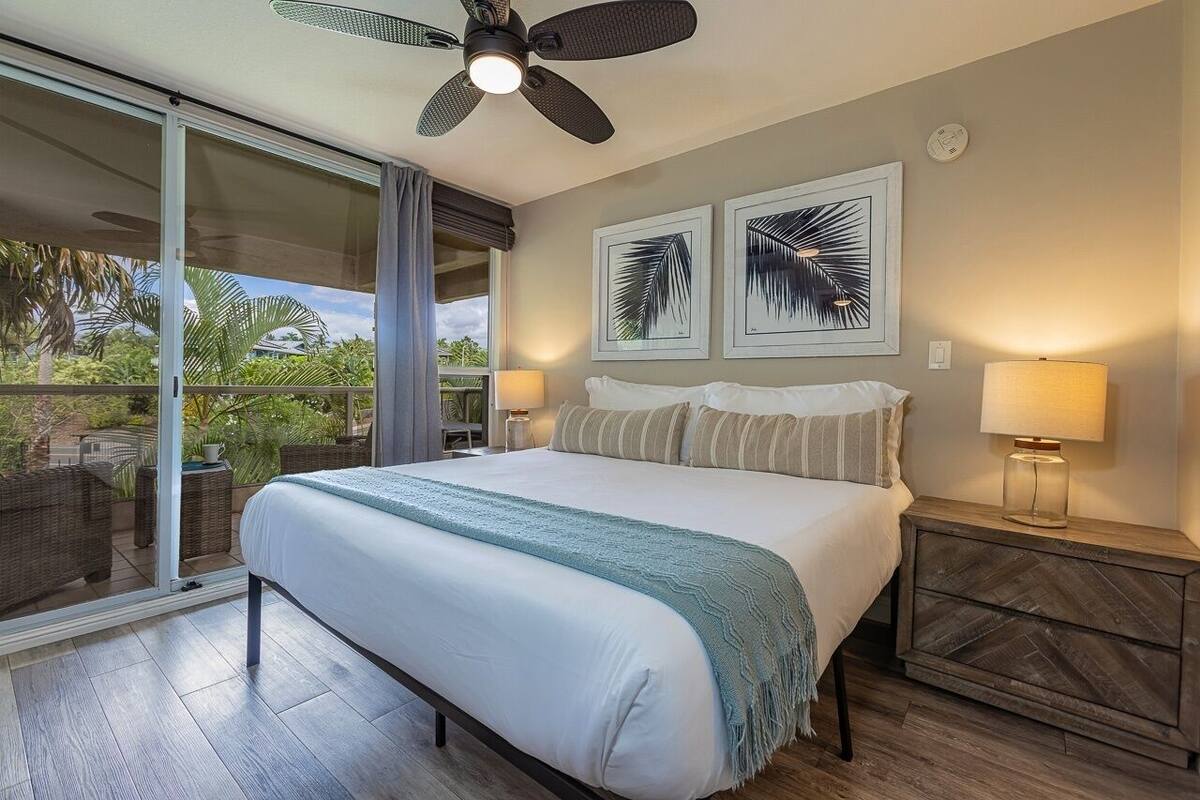Ein Schlafzimmer mit einem großen Bett, Deckenventilator und zwei Wandleuchten.