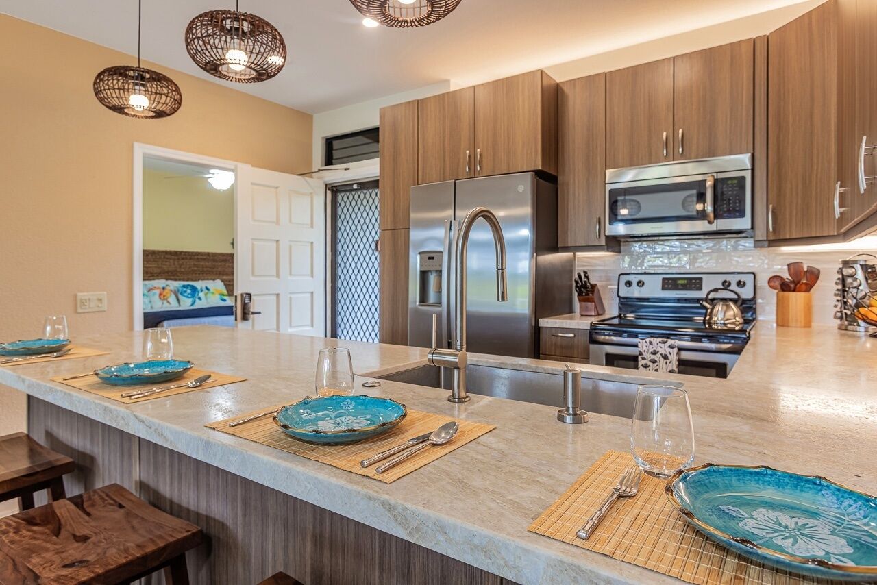 A modern kitchen with wooden cabinets, stainless steel appliances, and a central island with blue decorative plates.