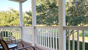 A covered porch with white railings and a table with chairs. - Reunion Retreat 3 Bedroom Home by RedAwning (Kissimmee)