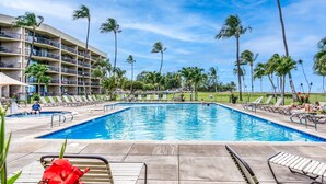 A swimming pool with lounge chairs and palm trees. - Maui Sunset B309 1 Bedroom Condo (Kihei)