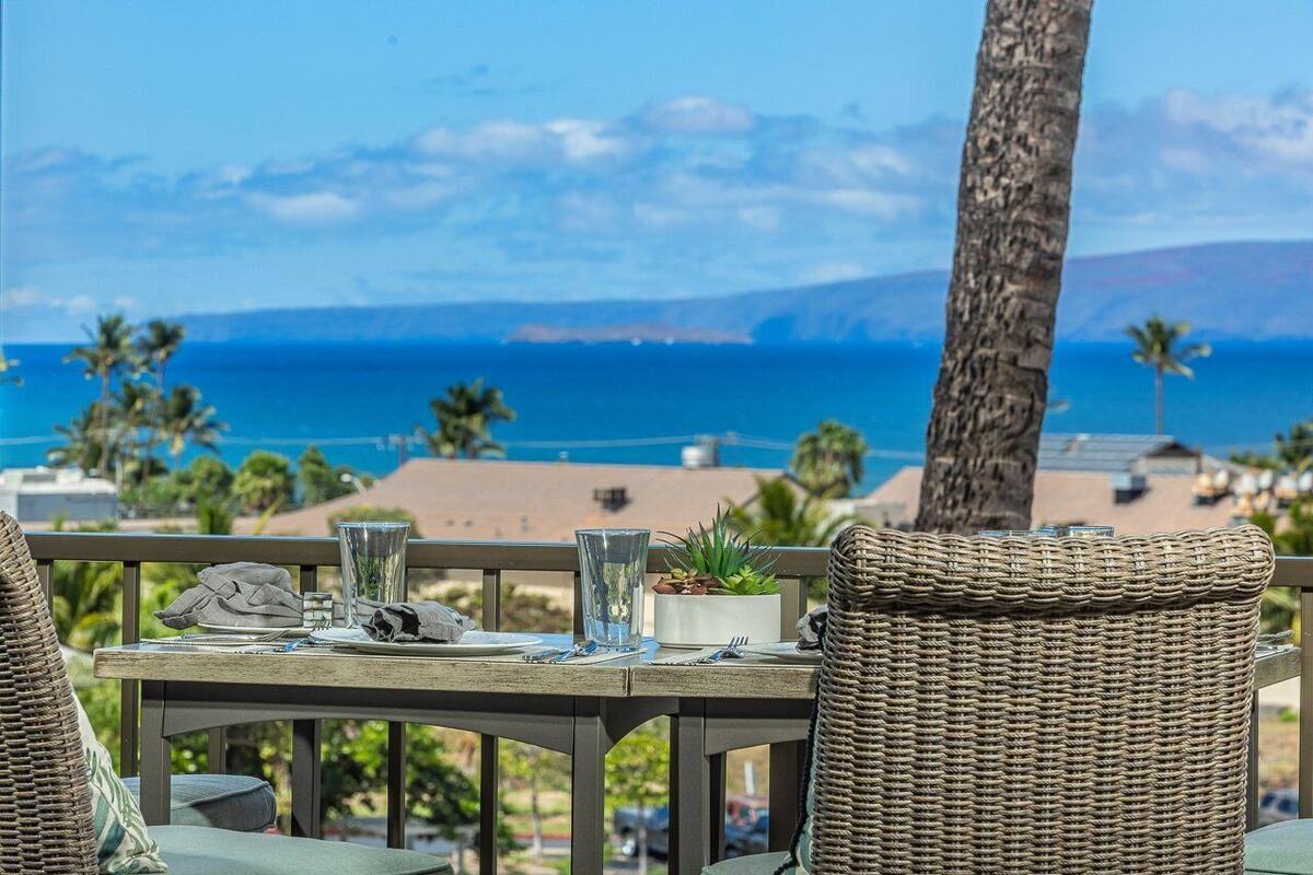 Ein Tisch für zwei mit Blick auf den Ozean, einer Topfpflanze und einem Glas Wasser.
