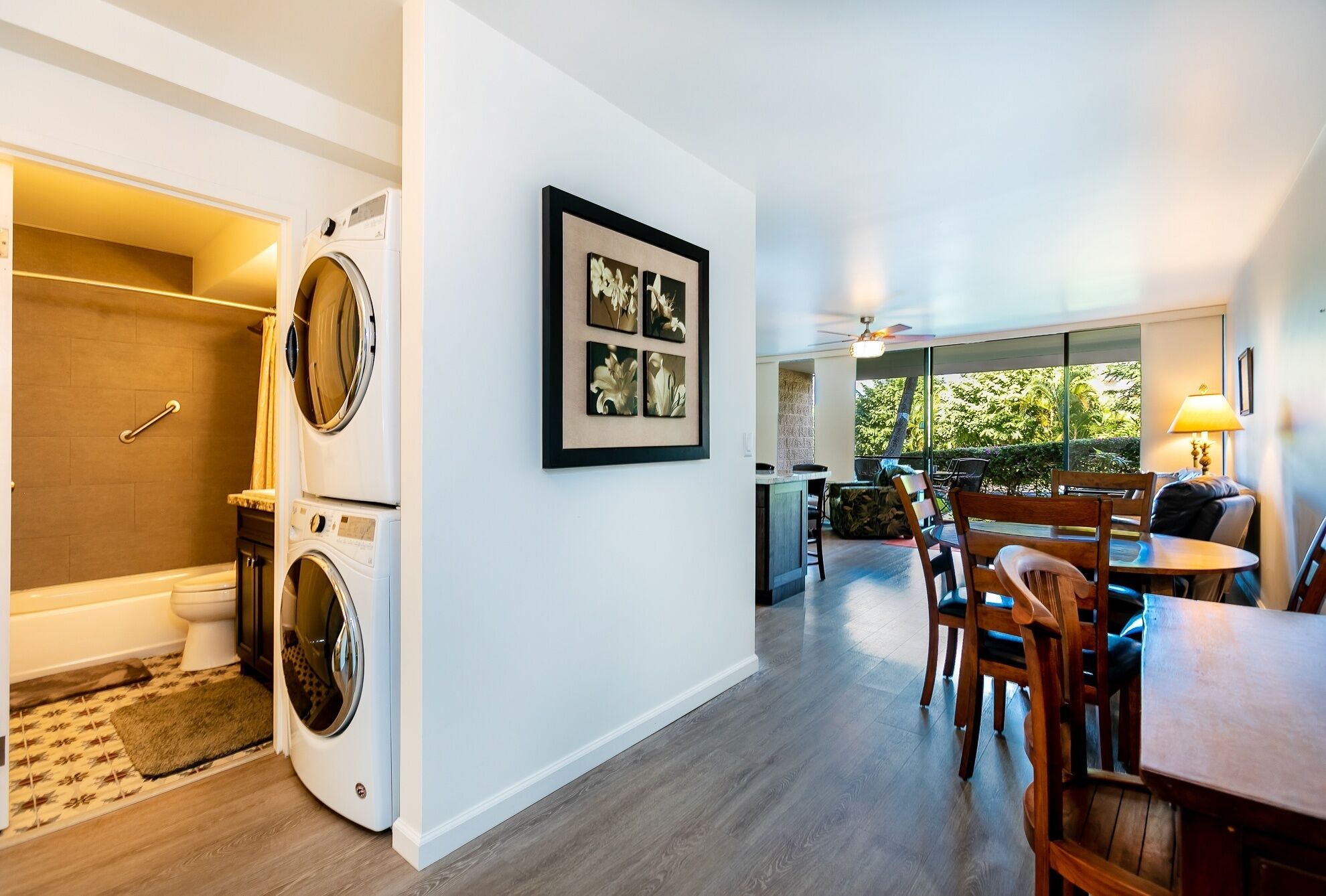 A modern apartment with a laundry area, a dining area with a view, and a kitchen.