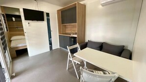 A compact living space with a kitchenette, a dining area, and a seating area. - D&I Mobile Home (Privlaka)