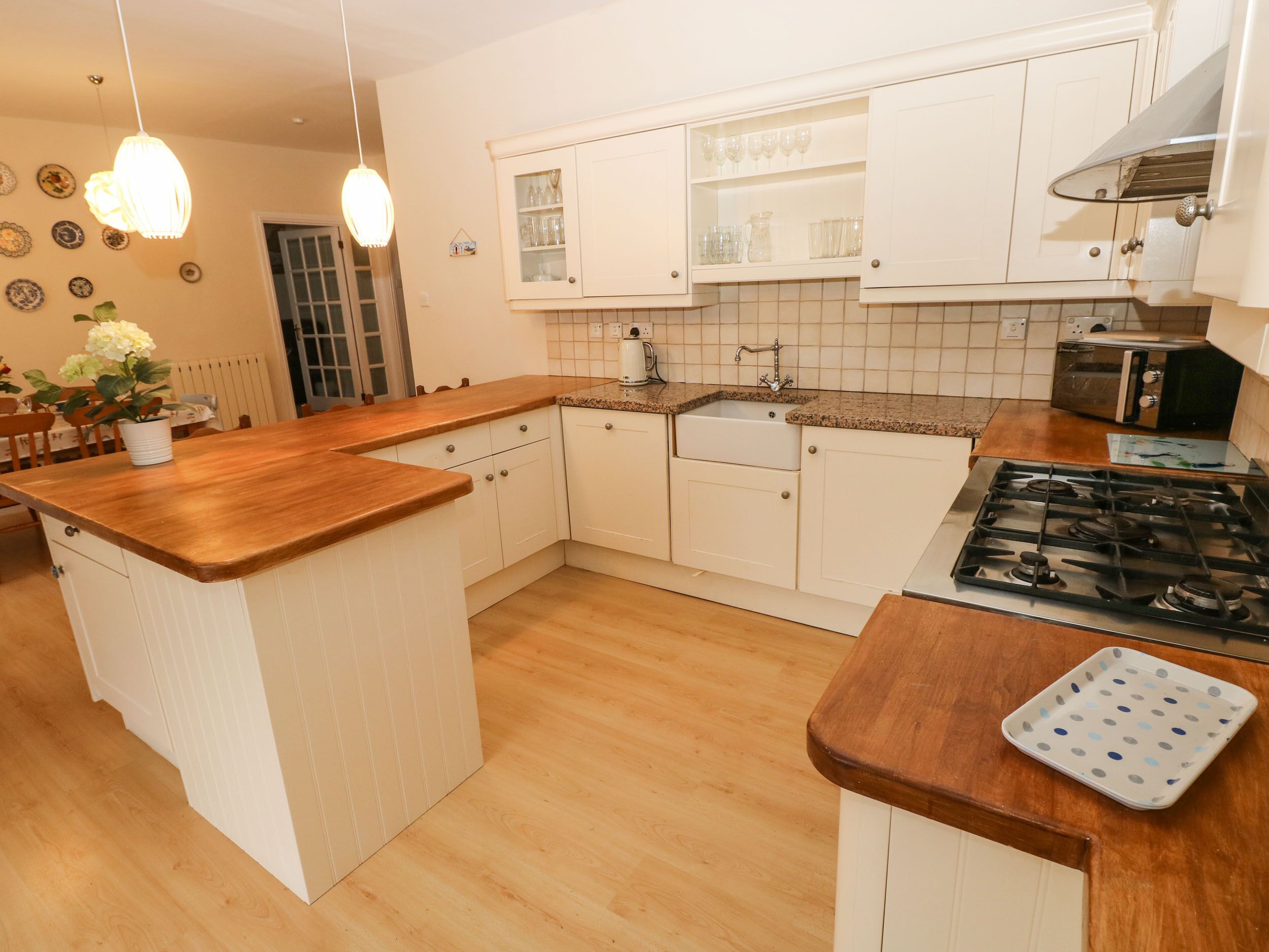 A kitchen with white cabinets, a granite countertop, a gas stove, and a microwave.