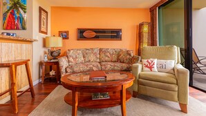 A living room with a sofa, armchair, coffee table, and decorative items. - Sugar Beach Resort, #121 1 Bedroom Condo by RedAwning (Kihei)
