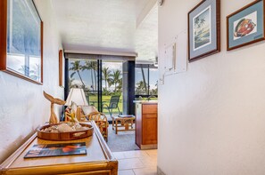 A room with a dining area, a view of the outdoors, and a kitchen area. - Kihei Surfside, #109 1 Bedroom Condo by RedAwning (Kihei)