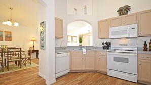 A kitchen with wooden cabinets, a white microwave, and a stove.