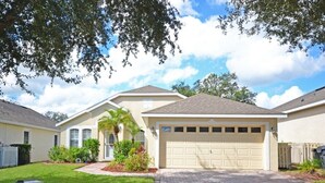 A single-story house with a garage, a well-maintained lawn, and a mailbox.