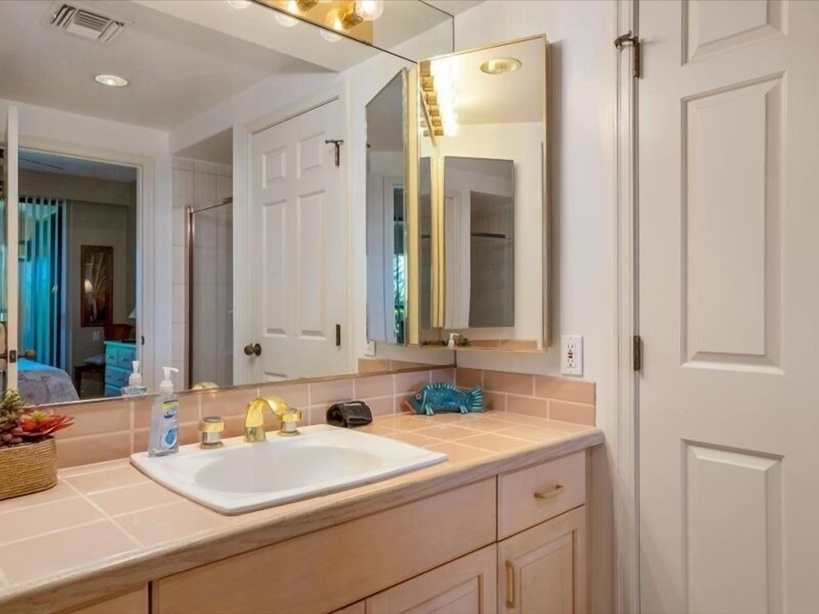 A bathroom with a white sink, a mirror, and a towel rack.