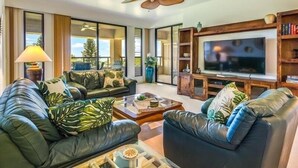 A modern living room with leather sofas, a large flat-screen TV, and a ceiling fan. - Big Island Waikoloa Fairways by Coldwell Banker Island Vacations (Waikoloa)