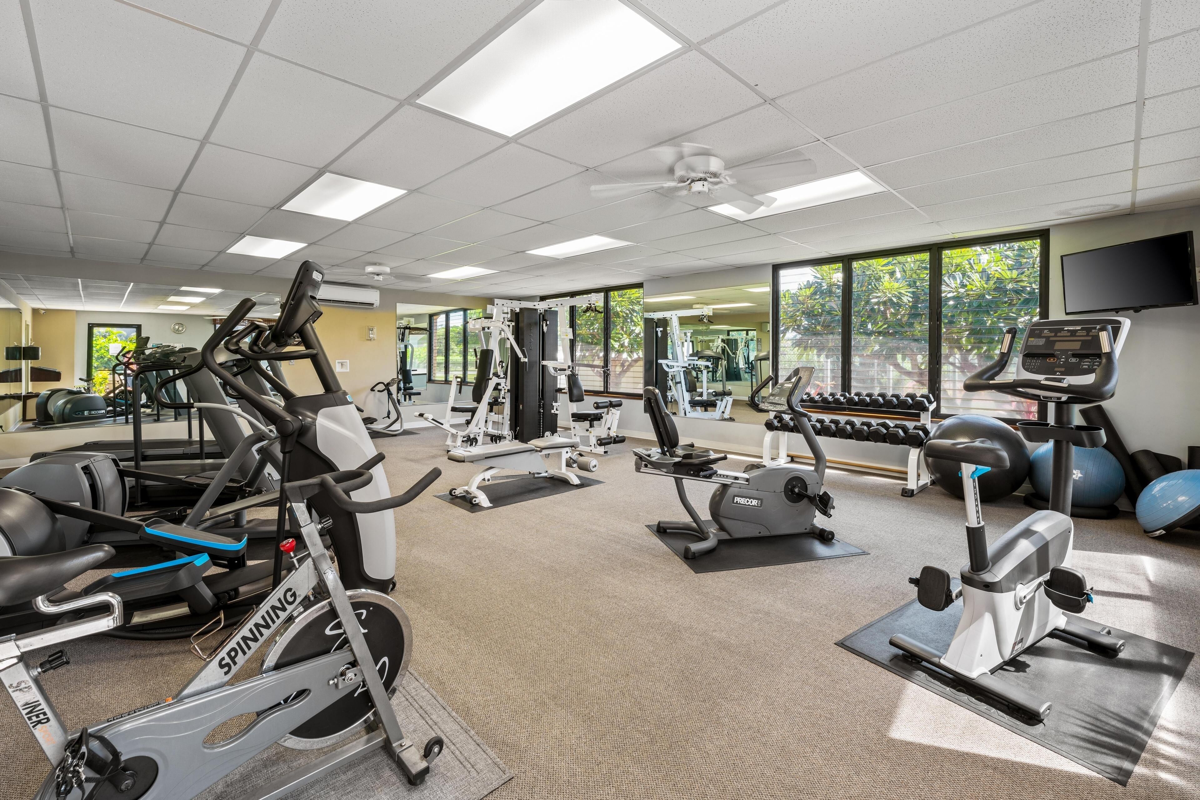 A gym with various exercise equipment, including treadmills, stationary bikes, and weight machines.