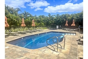 A swimming pool with lounge chairs and umbrellas, surrounded by palm trees. - Wailea Elua, #0302 1 Bedroom Condo by RedAwning (Kihei)