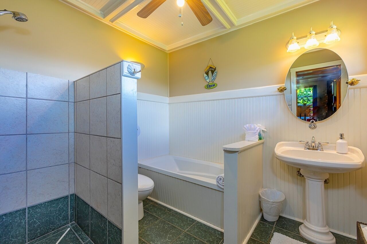 A bathroom with a bathtub, toilet, sink, and shower.