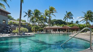 A clear pool with lounge chairs, palm trees, and a waterfall in the background. - Big Island Fairways At Mauna Lani 1705 3 Bedroom Townhouse (Kamuela)