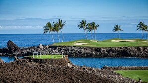 A coastal golf course with a rocky shoreline, palm trees, and a clear view of the ocean. - Big Island Fairways At Mauna Lani 1705 3 Bedroom Townhouse (Kamuela)