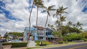 A two-story building with a blue facade, a sign for 'Mako Jewelry', and palm trees in the background. - Kihei Kai Nani by Coldwell Banker Island Vacations (Kihei)