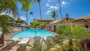 A swimming pool with lounge chairs and palm trees. - Kihei Kai Nani by Coldwell Banker Island Vacations (Kihei)