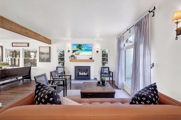 A living room with a fireplace, seating area, and large windows. - New! Spacious Detached Home | Perfect Location (Avalon)