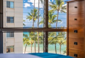 A room with a view of palm trees and the ocean through a window. - Kamaole Nalu, #502^ 2 Bedroom Condo by RedAwning (Kihei)