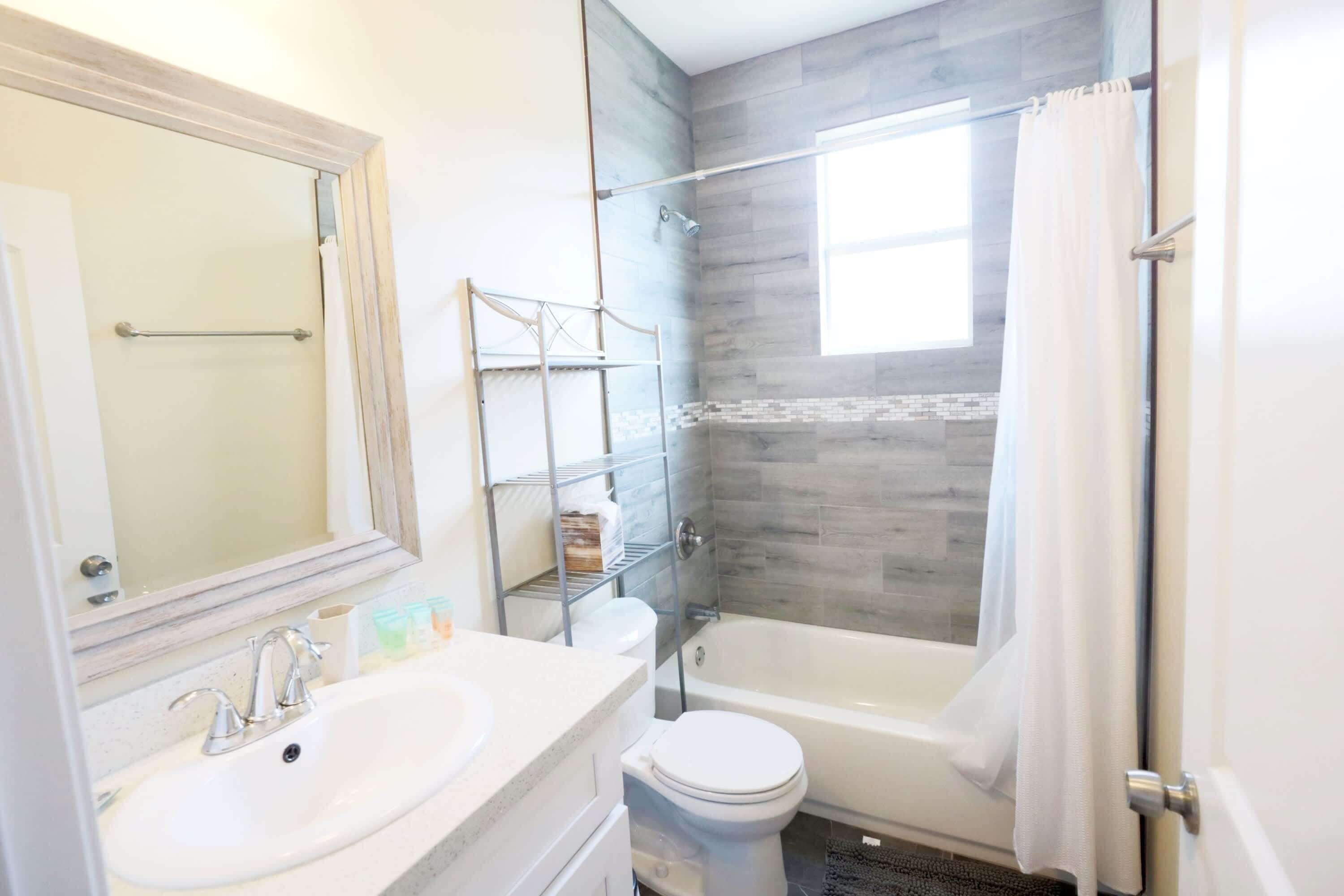 A modern bathroom with a bathtub, toilet, and sink.