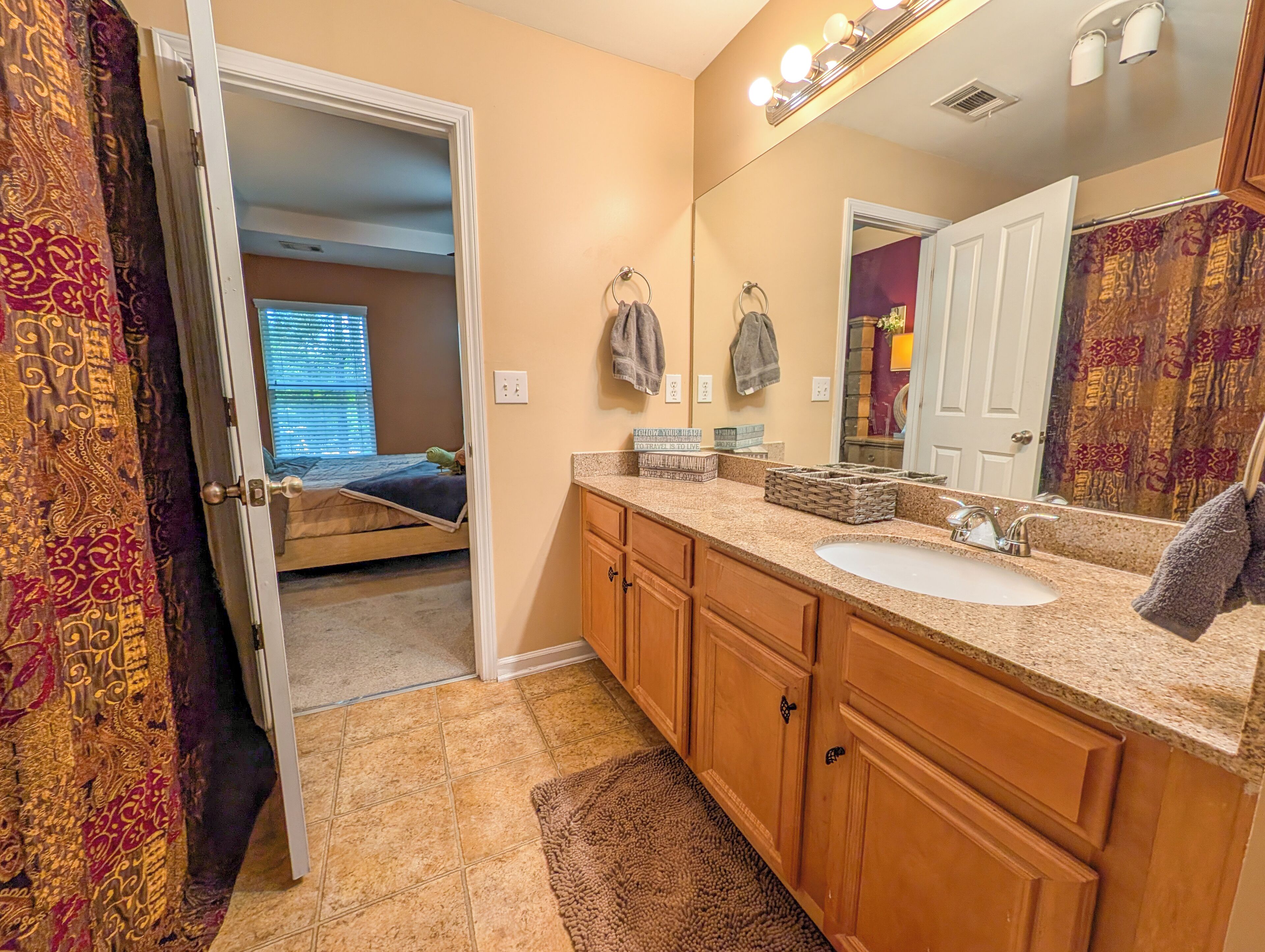 A bathroom with a sink, mirror, and towel rack.