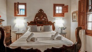 A bedroom with a large wooden bed, two bedside lamps, and a window with curtains. - Beach Villa Aralinn by Hello Homes Sitges (Sitges)