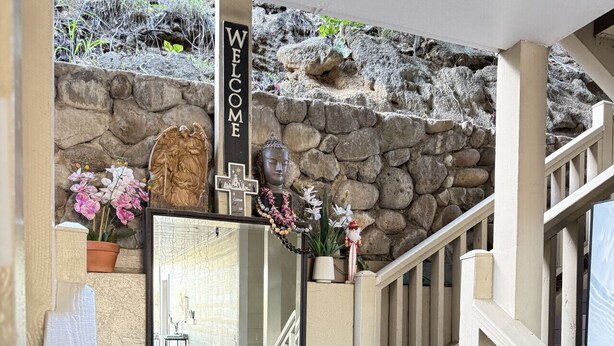A staircase leading to a stone wall with a 'WELCOME' sign, a framed mirror, and potted plants. - Unit 22 Waena Inn - Maui Private Suite (Wailuku)
