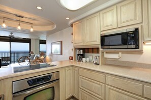 A modern kitchen with a built-in oven, microwave, and coffee maker. - Kihei Beach, #509 2 Bedroom Condo by RedAwning (Kihei)