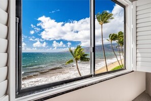 A window with a view of a beach, palm trees, and a clear sky. - Kihei Beach, #409 2 Bedroom Condo by RedAwning (Kihei)