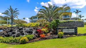 A landscaped area with a stone wall, a small waterfall, and a sign reading "Na Hale Keauhou". - Big Island Na Hale O Keauhou by Coldwell Banker Island Vacations (Kailua-Kona)