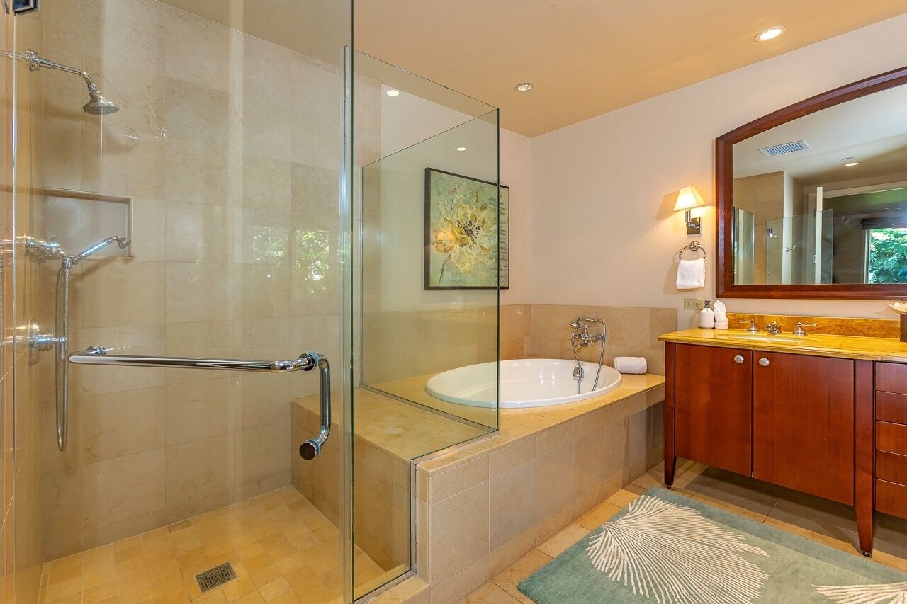 A modern bathroom with a glass-enclosed shower, a freestanding bathtub, and wooden cabinetry.