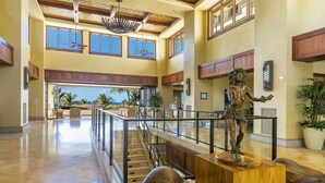 Eine geräumige Lobby mit hoher Decke, großen Fenstern und einer zentralen Treppe.