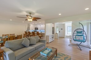 A spacious living area with a sofa, dining table, and chairs, a kitchen in the background, and a ceiling fan. - Kaanapali Plantation by Coldwell Banker Island Vacations (Lahaina)